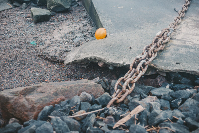 A lonely orange balloon laying in an industrial area