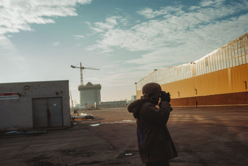 Man taking a photograph in an industrial area