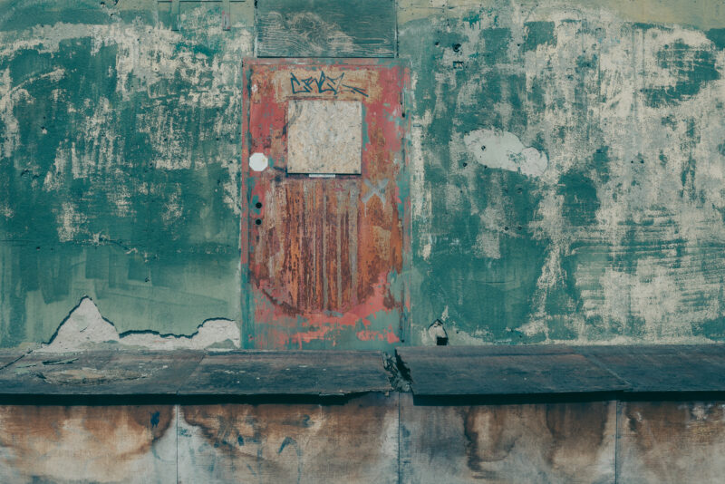 Red door on a well-worn green wall
