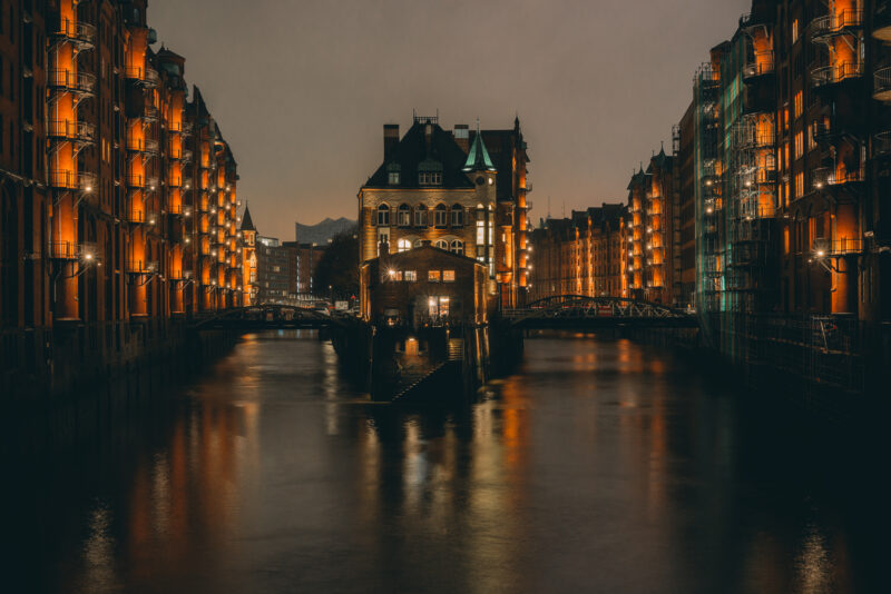 Houses in Speicherstadt (Hamburg) reflecting in the dark water of the channel.