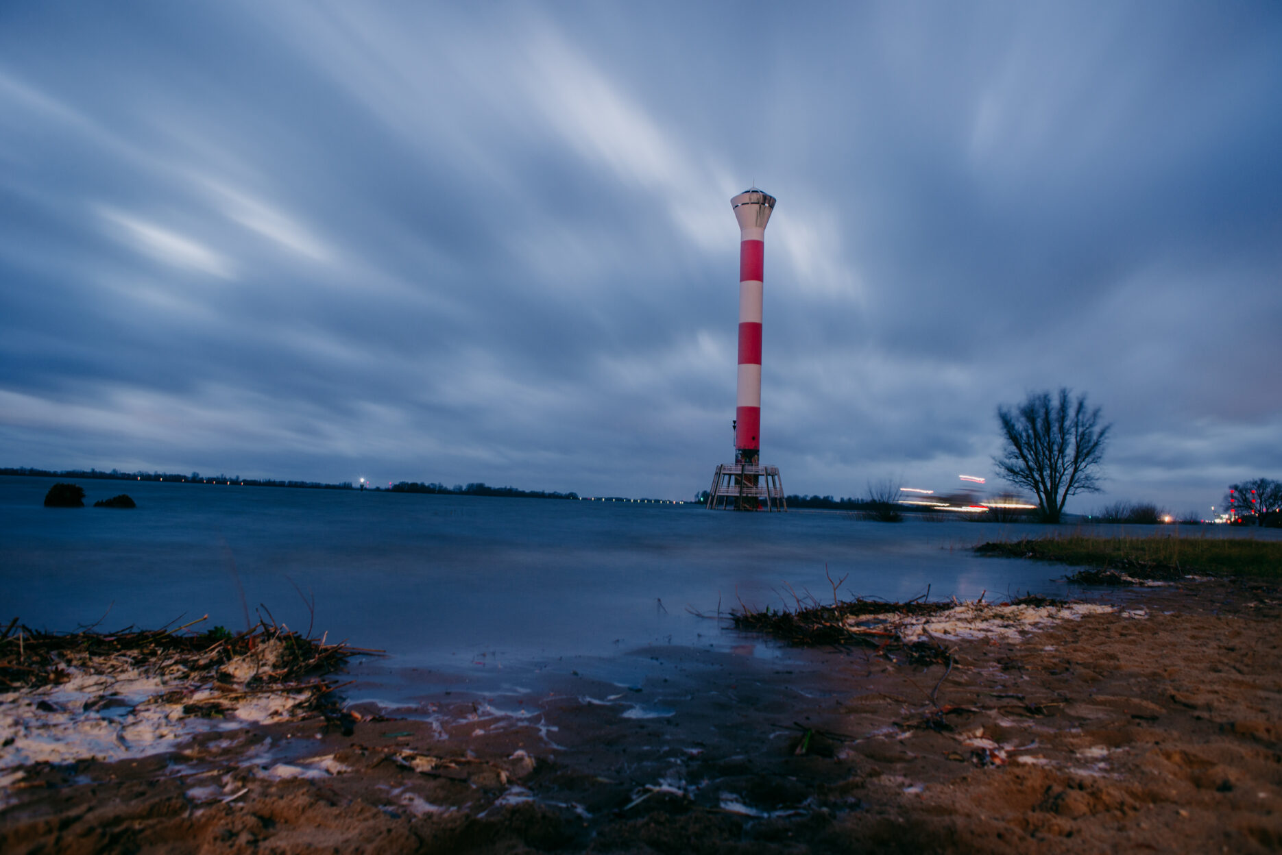 Red and white lighthouse on a flooded beach