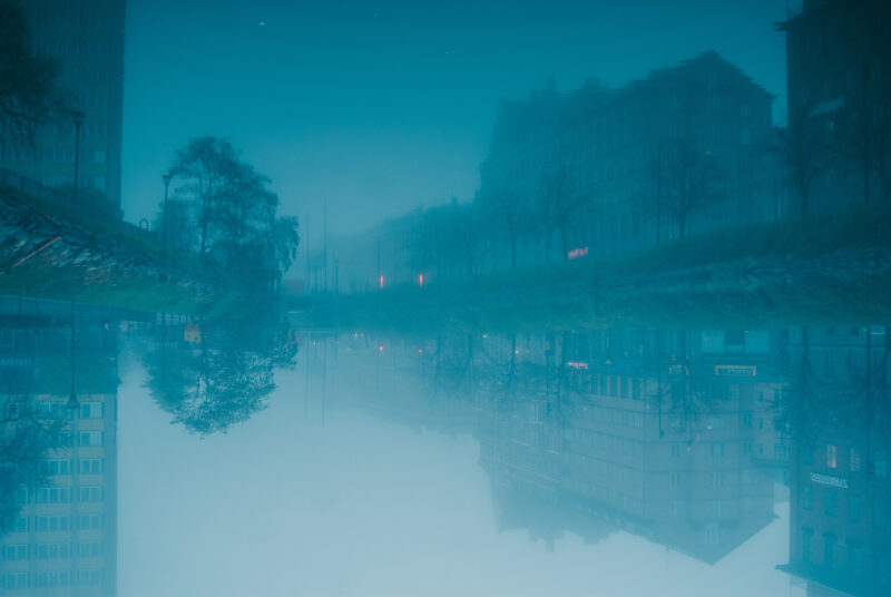 Houses reflecting in Malmö kanal during foggy weather